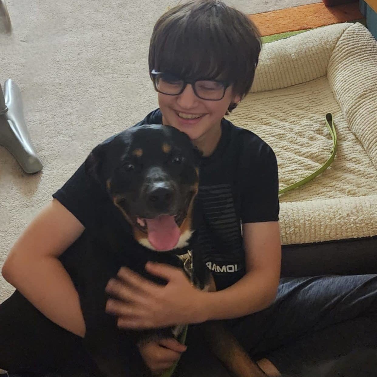 King the dog being hugged by one of his owners