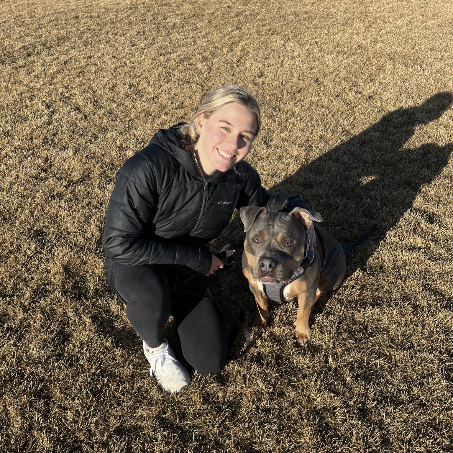 Woman with her dog in grass field