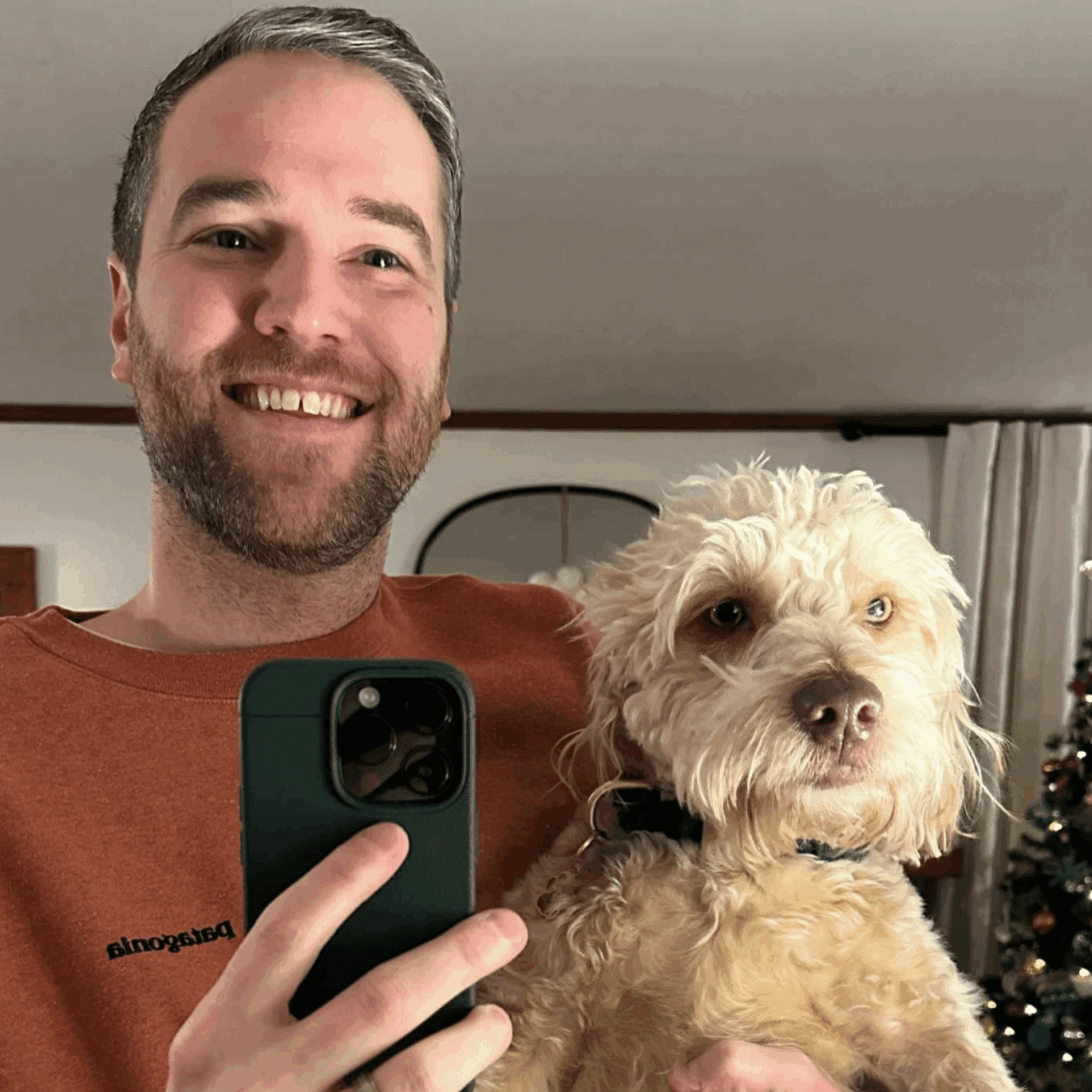 Man taking a selfie while holding his dog