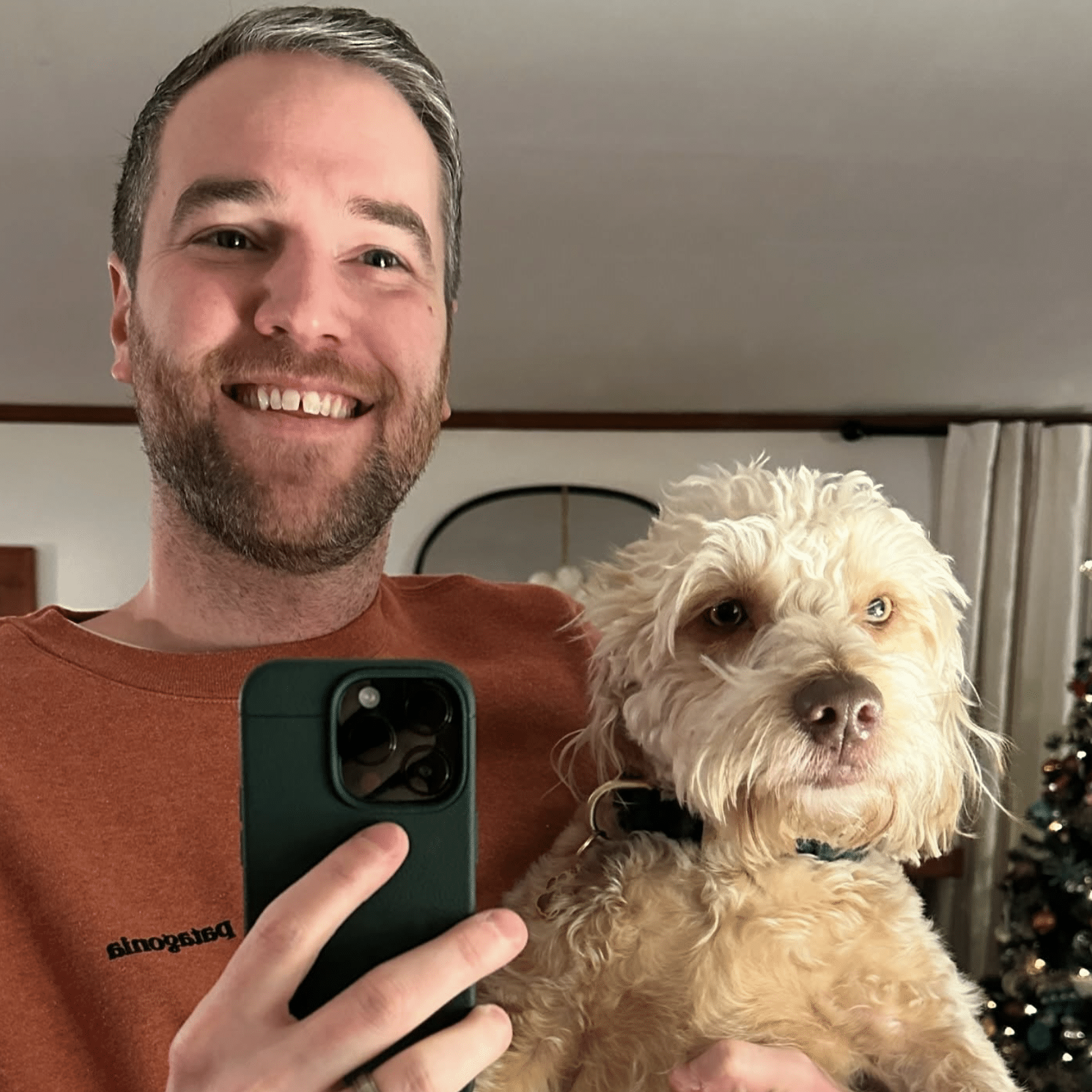 Man taking a selfie while holding his dog