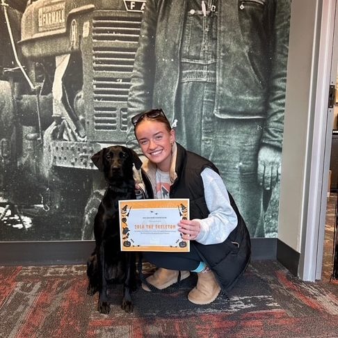 Zola the dog posing for a photo with her owner outside